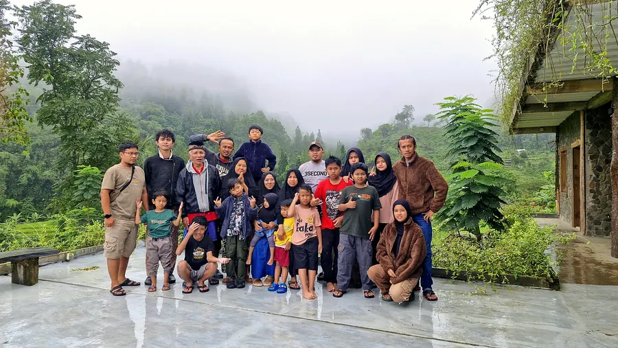 Rombongan keluarga berfoto di tengah kabut