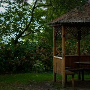 a gazebo with a table and bench in the grass